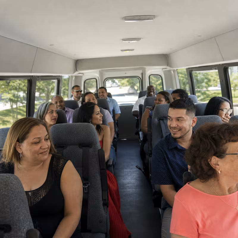 Group boarding a white charter bus for Private Event Transportation transportation in Fort Wayne