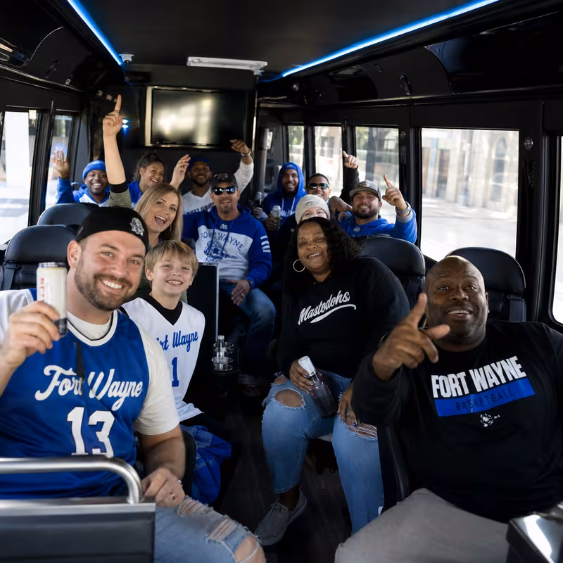 Group boarding a white charter bus for Sporting Event Transportation transportation in Fort Wayne